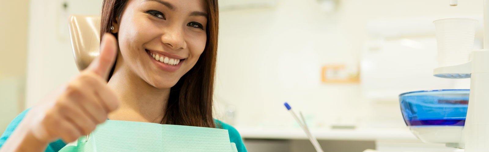 Smiling asian woman sitting at the dentist